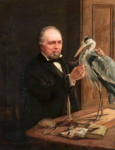 Portrait of Morris Young preparing an exhibit of a bird