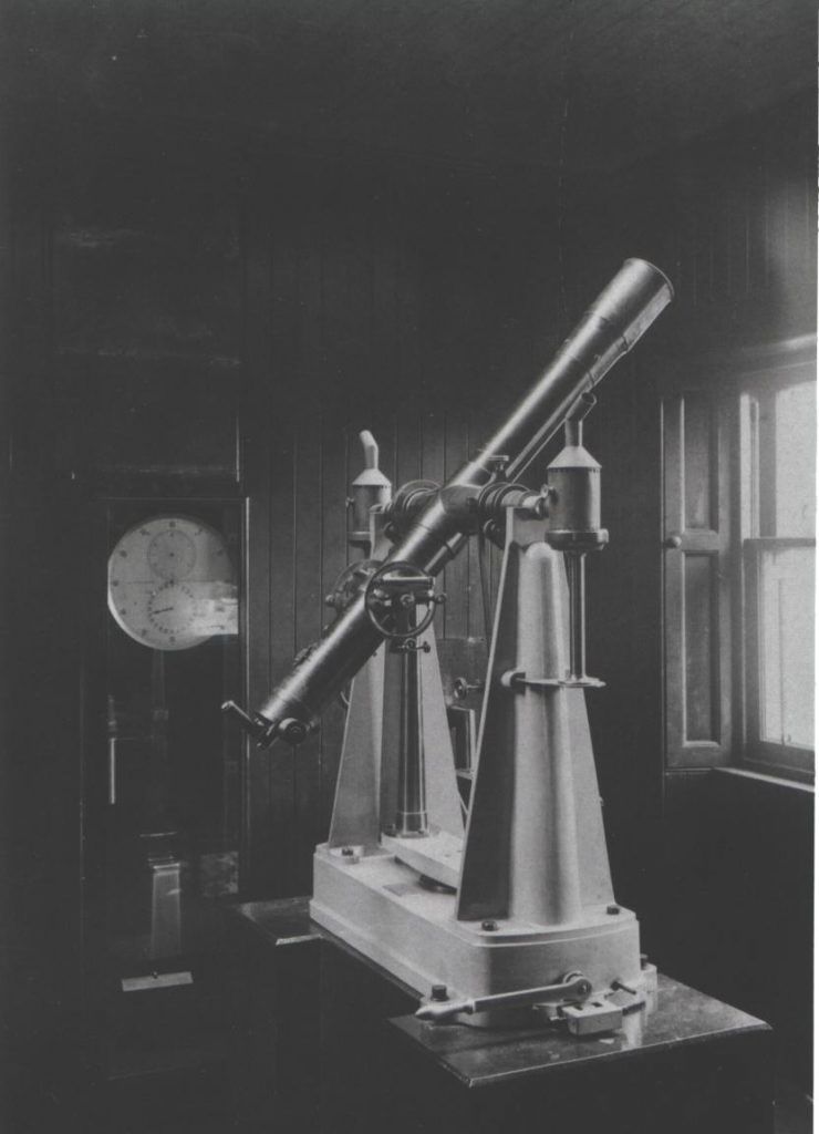 A black and white photograph of the transit telescope and side reel clock.