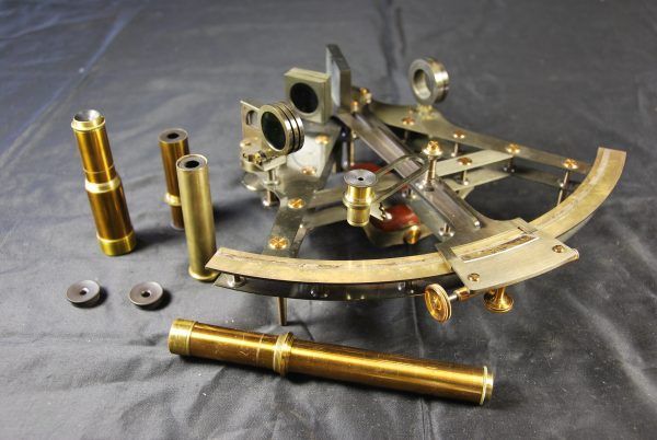 Victorian sextant and lens attachments lying on its side
